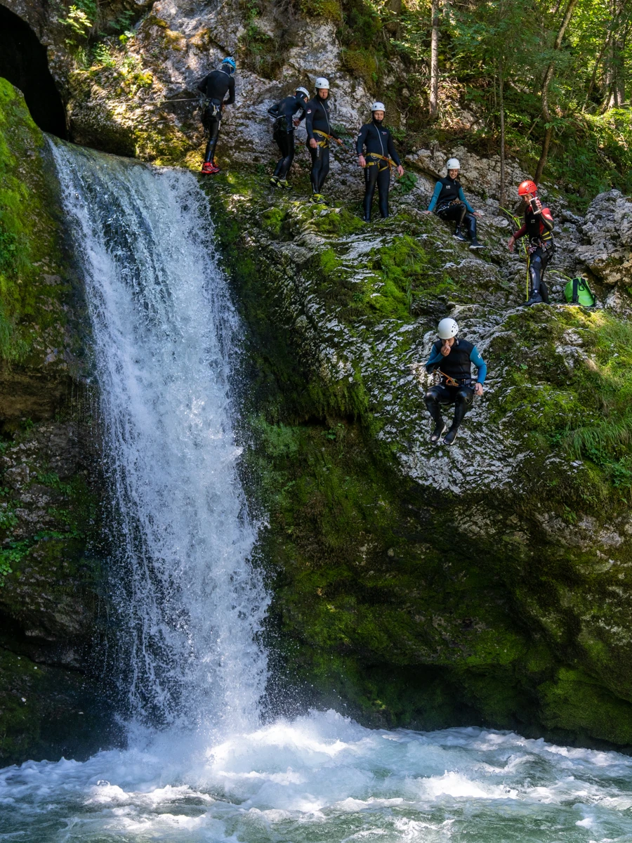 Group canyoning near waterfall in Grmecica Canyon Slovenia