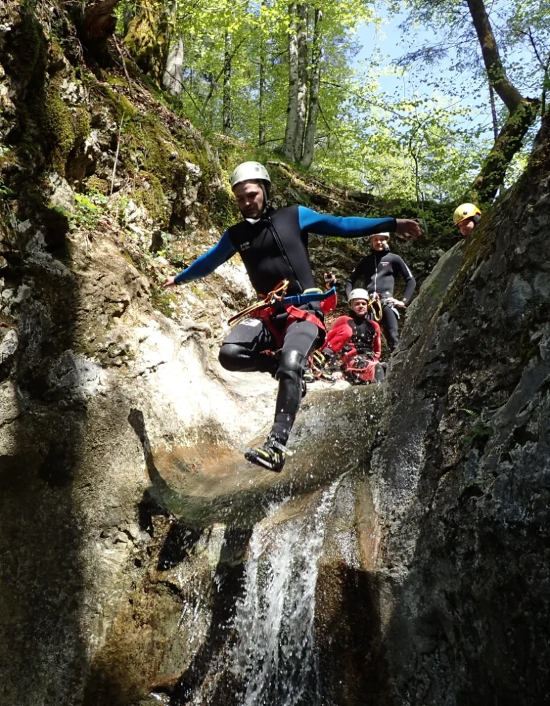 Canyoneer jumps through narrow rocks in Jerečica Canyon Slovenia