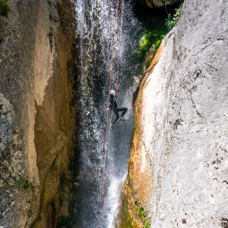Canyoner rappeling down in a mighty waterfall in Globoski Potok