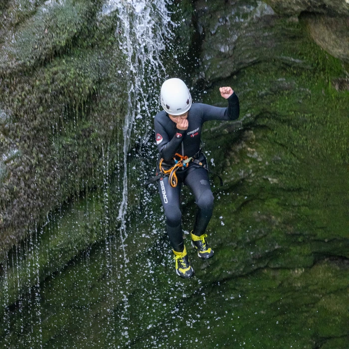 Canyoner jumping through the waterfall in Grmečica Canyon near Bled, Slovenia